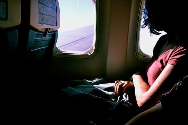girl looking out of an airplane window