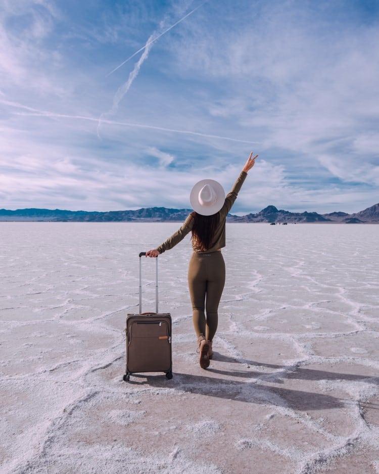https://www.jasminealley.com/wp-content/uploads/2023/01/woman-traveling-with-suitcase-bonneville-salt-flats-utah.jpg