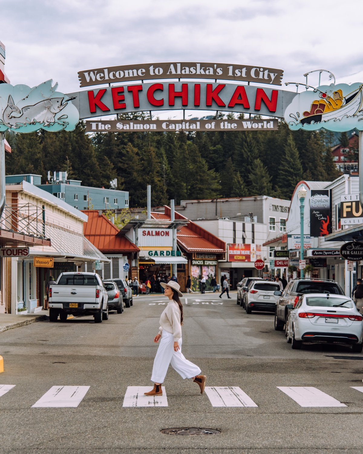 Girl walking in front of welcome to Ketchikan sign