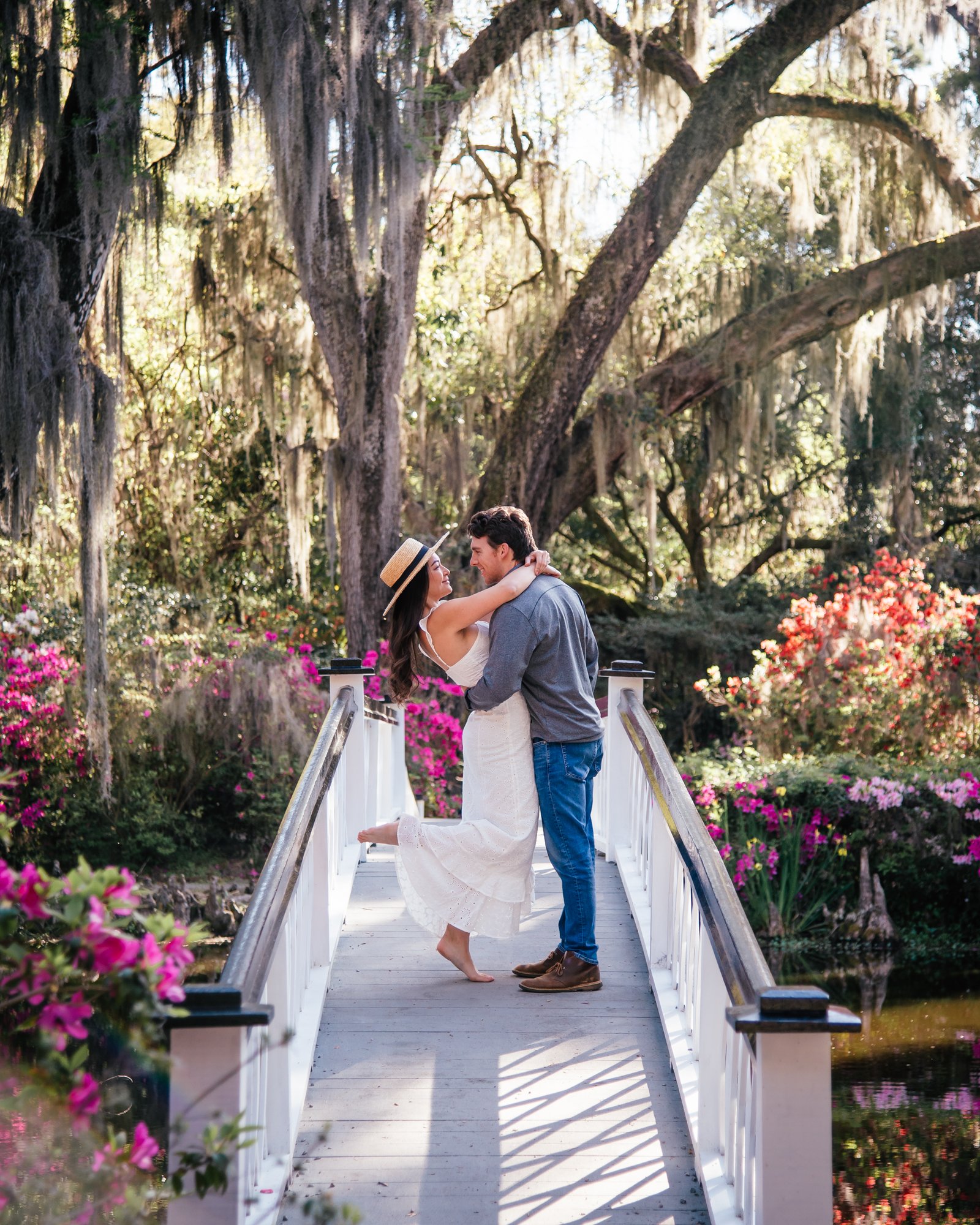 A couple poses on the white bridge at Magnolia Plantation in Charleston