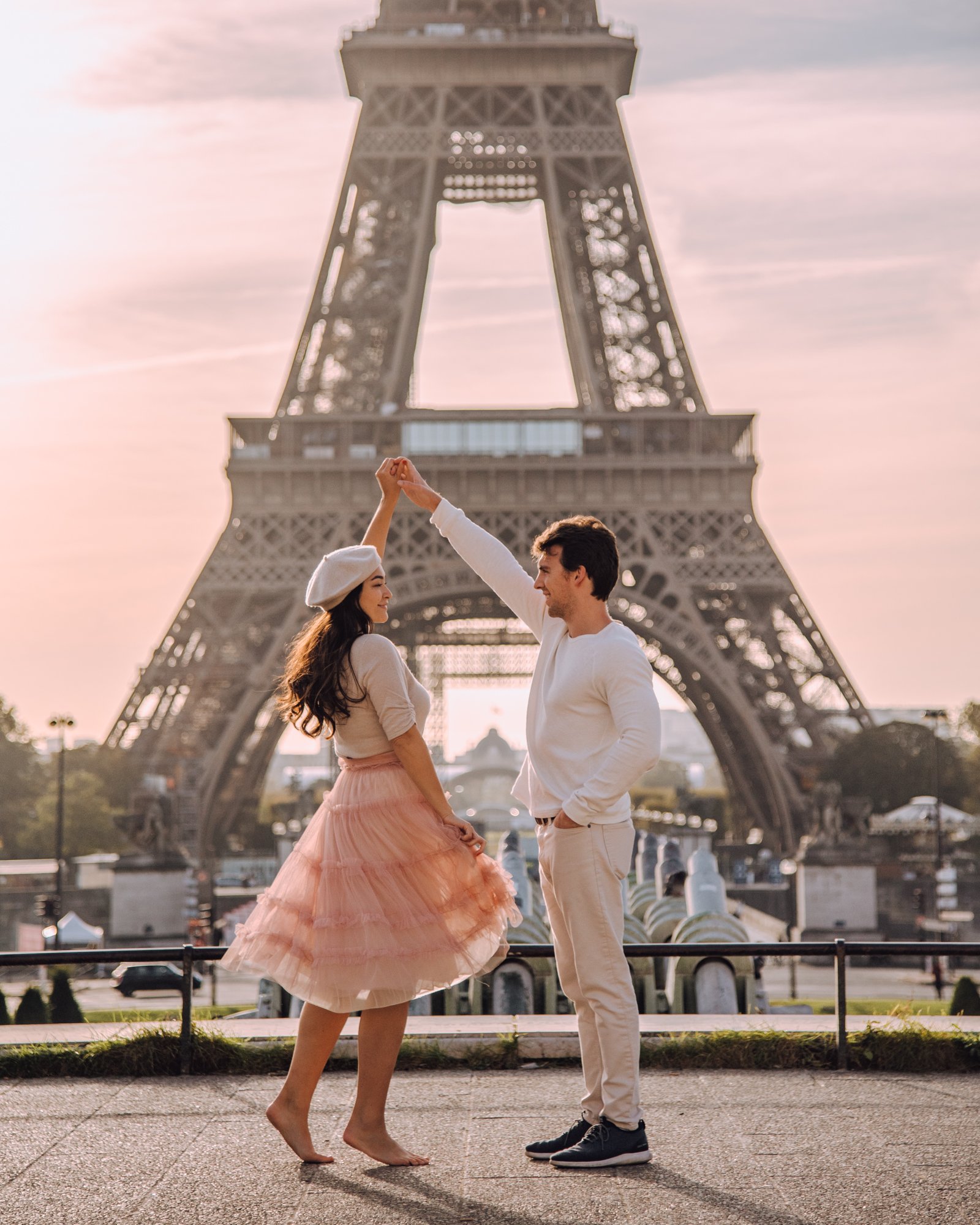 Guy twirls girl in front of the Eiffel Tower in Paris at the Trocadero